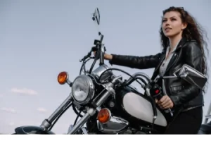 Das Gefühl von Freiheit auf einem Motorrad. Eine Frau/Bikerin schaut in den blauen Himmel,.