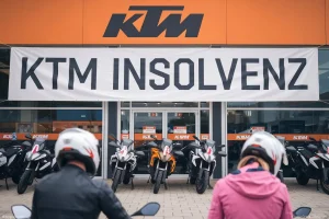 KTM Motorräder und zwei besorgte Biker vor dem Geschäft, das von der KTM Insolvenz betroffen ist.