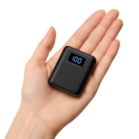 Eine Hand hält eine kleine schwarze Powerbank – ein kompaktes Beispiel für praktische Biker Gadgets.