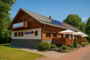 Die Bavaria Alm Garbsen an einem sonnigen Tag – das rustikale Alpenrestaurant aus Holz und Stein ist umgeben von grüner Natur.