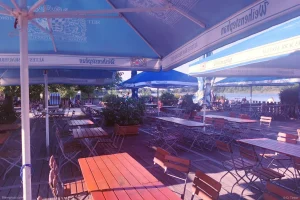 Sonniger Blick auf den Außenbereich vom Motorradtreff Seehaus Isernhagen – gemütliche Biergarten-Atmosphäre direkt am See, ideal für eine entspannte Pause bei gutem Wetter.