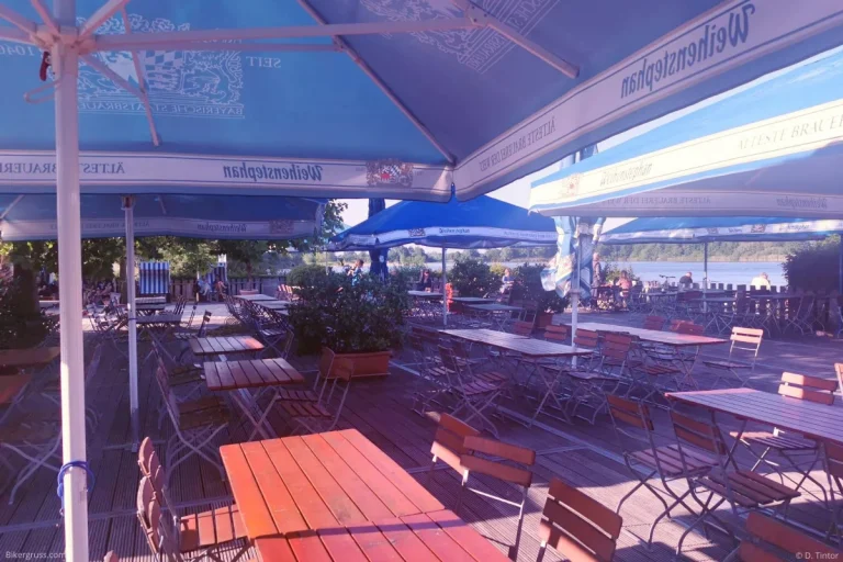 Sonniger Blick auf den Außenbereich vom Motorradtreff Seehaus Isernhagen – gemütliche Biergarten-Atmosphäre direkt am See, ideal für eine entspannte Pause bei gutem Wetter.